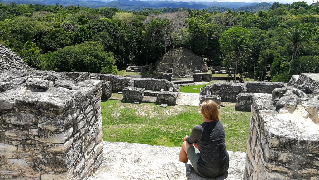 Woman sitting down overlooking the view from atop a Mayan temple in Belize